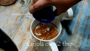 Adding canola oil to chocolate mug cake in air fryer