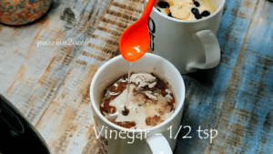 Adding vinegar to chocolate mug cake in air fryer
